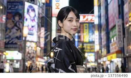 夜の秋葉原でネオンに照らされる黒い着物姿の日本人女性 137356490
