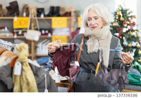Uncertain mature woman choosing bra in clothing store Uncertain mature woman choosing bra in clothing store 137356586