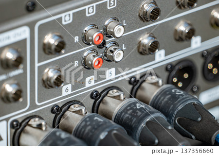 Professional sound mixer panel with various audio connections and XLR cables plugged in Professional sound mixer panel with various audio connections and XLR cables plugged in 137356660