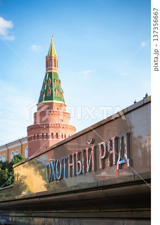 Okhotny Ryad metro sign with the historic Moscow Kremlin tower under a blue sky Okhotny Ryad metro sign with the historic Moscow Kremlin tower under a blue sky 137356667