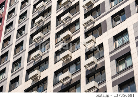 Residential building facade showing modern architecture and many windows with air conditioners Residential building facade showing modern architecture and many windows with air conditioners 137356681