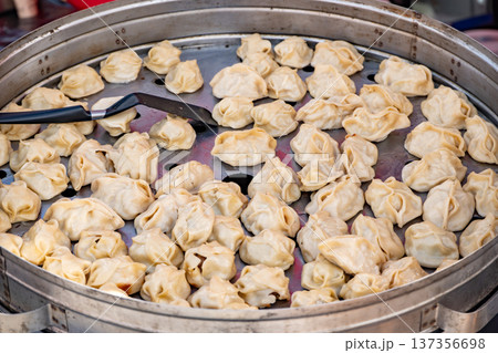 Manta dumplings steaming in a metal tray at a Central Asian street food market Manta dumplings steaming in a metal tray at a Central Asian street food market 137356698