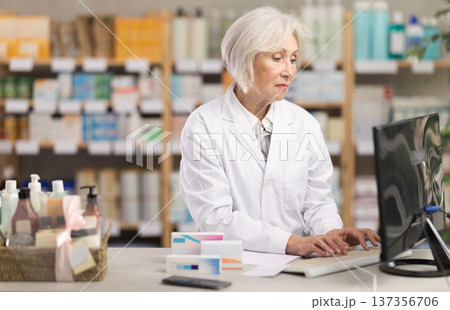 Female pharmacist working at computer in pharmacy 137356706