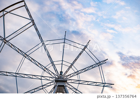 Ferris wheel structure against a colorful sky at sunset, amusement park construction 137356764