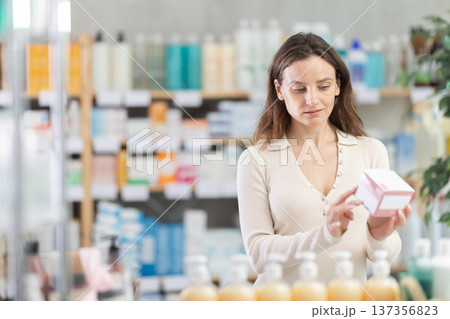 Girl in summer clothes buys medicinal ointment at pharmacy Girl in summer clothes buys medicinal ointment at pharmacy 137356823