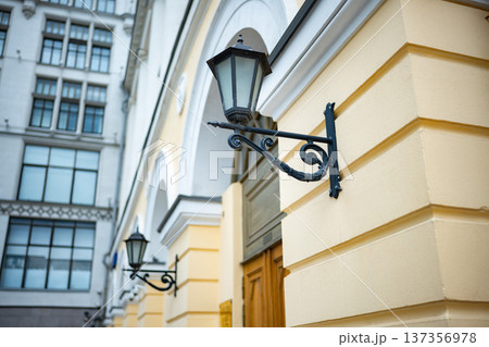 Ornate vintage street lamp on old building facade with classic architecture Ornate vintage street lamp on old building facade with classic architecture 137356978