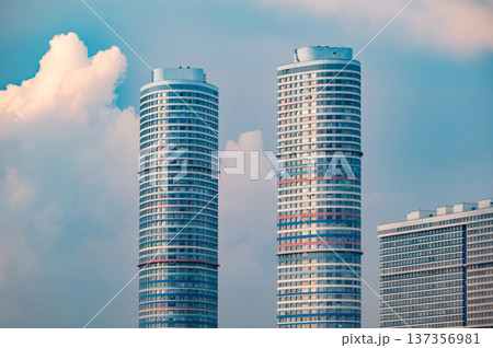 Modern city skyline with two tall residential skyscrapers reaching up to blue sky 137356981
