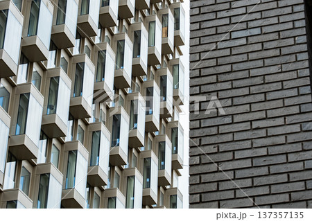 Modern building facade featuring bay windows and contrasting brick patterns Modern building facade featuring bay windows and contrasting brick patterns 137357135