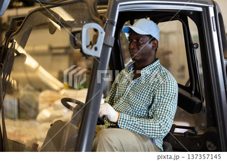 Man driving fork lift in storehouse 137357145