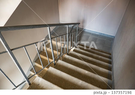 Concrete staircase leading down with metal handrail and sun shadows Concrete staircase leading down with metal handrail and sun shadows 137357198