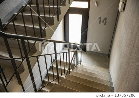 Concrete staircase leading to apartment number 14 door in urban building interior Concrete staircase leading to apartment number 14 door in urban building interior 137357200