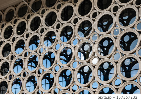 Modern building facade featuring abstract circular pattern and glass windows 137357232