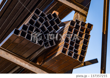 Stacking square metal steel pipes creating an industrial architecture background Stacking square metal steel pipes creating an industrial architecture background 137357255