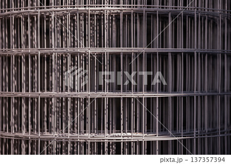 Rolled welded wire mesh fencing material creating abstract geometric pattern 137357394