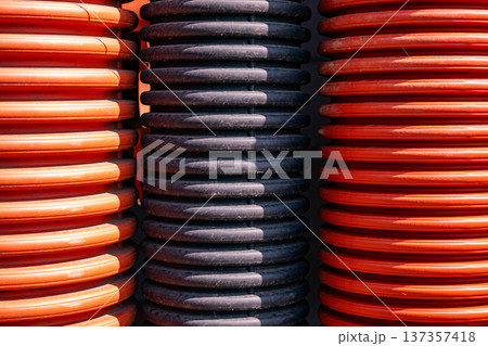Corrugated orange and black pipes forming a ribbed industrial texture background Corrugated orange and black pipes forming a ribbed industrial texture background 137357418