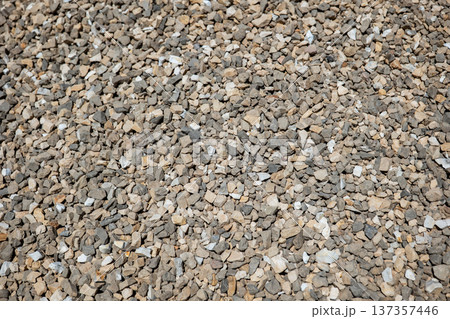Rough gravel texture forming a natural background with small gray and tan stones Rough gravel texture forming a natural background with small gray and tan stones 137357446