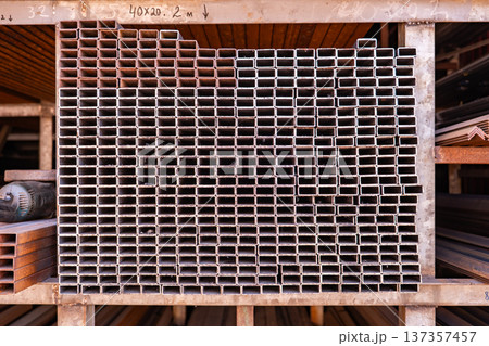 Stacked rectangular metallic profiles in a warehouse for construction and industry 137357457