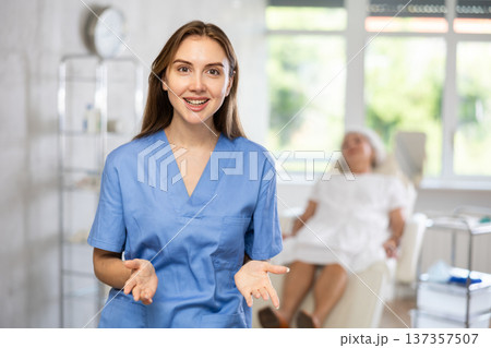 Portrait of young female doctor in scrub. Portrait of young female doctor in scrub. 137357507