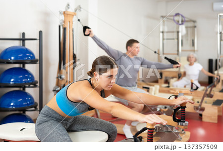 Young woman stretching her arms using pilates machine 137357509