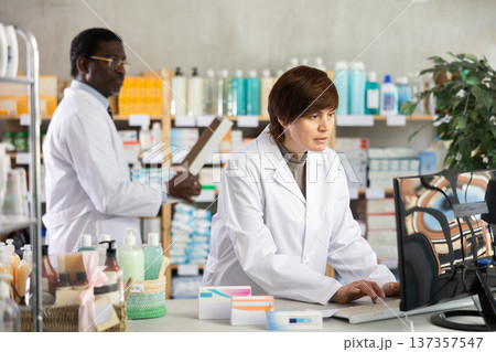 Female pharmacist working at computer in pharmacy 137357547