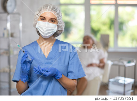 Young doctor with mask and syringe Young doctor with mask and syringe 137357551