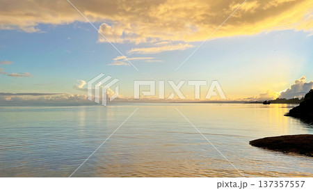 朝焼けの静かな海と黄金色に輝く幻想的な雲の風景　沖縄県今帰仁村 137357557