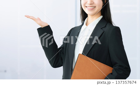 案内をする若い女性・ビジネスウーマン 137357674