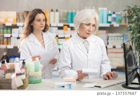 Two female pharmacists employee using computer Two female pharmacists employee using computer 137357687
