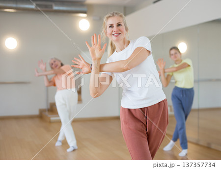 Woman dancing during group rehearsal in studio Woman dancing during group rehearsal in studio 137357734