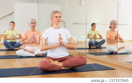 Continuity of generations - family in lotus position doing yoga in gym 137357845