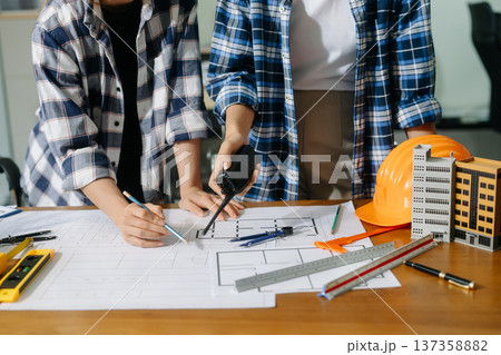 Engineer teams meeting working together wear worker helmets hardhat on construction site in modern city 137358882