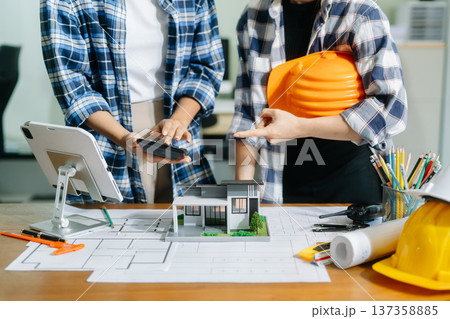Engineer teams meeting working together wear worker helmets hardhat on construction site in modern city 137358885