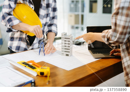 Creative architect projecting on the big drawings with architectural project at construction site at desk i 137358890