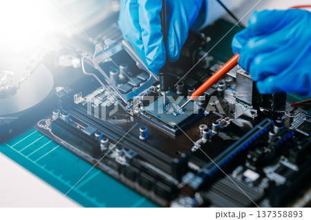 The technician is putting the CPU on the socket of the computer motherboard. electronic engineering electronic repair, electronics measuring and testing, repair 137358893