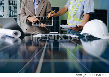 Engineers collaborate on solar and wind energy, driving sustainability, innovation, and clean tech solutions. Engineers collaborate on solar and wind energy, driving sustainability, innovation, and clean tech solutions. 137358935