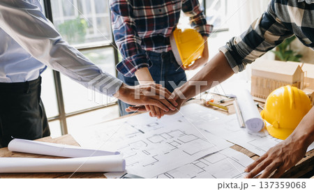 Close up shot of scale model house on table with architects. Two architects making architectural model in office together. to form a new building 137359068