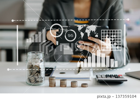 saving money with hand putting coins in jug glass and calculator to calculate budget concept finance and accounting and Gantt chart diagram. screen 137359104