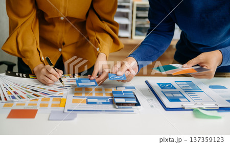 UX developer and ui designer brainstorming about mobile app interface wireframe design with customer breif and color code 137359123