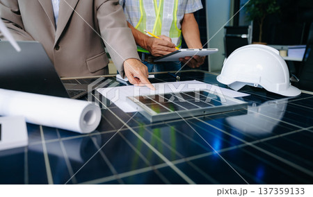 Engineers collaborate on solar and wind energy, driving sustainability, innovation, and clean tech solutions. 137359133