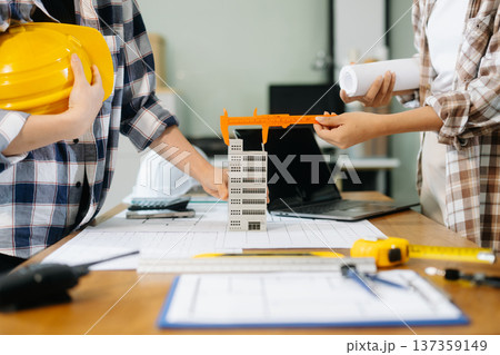 Creative architect projecting on the big drawings with architectural project at construction site at desk i Creative architect projecting on the big drawings with architectural project at construction site at desk i 137359149