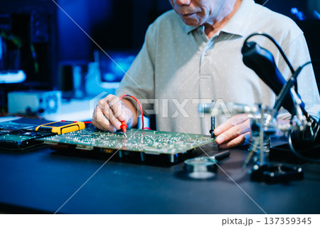 Closeup of expert soldering a green PCB board using precision tools. Ideal for electronics, circuit repair, engineering, tech 137359345