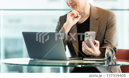 パソコンとスマートフォンを使う男性ビジネスマン パソコンとスマートフォンを使う男性ビジネスマン 137359400
