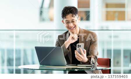 パソコンとスマートフォンを使う男性ビジネスマン パソコンとスマートフォンを使う男性ビジネスマン 137359403