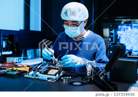 Professional electronics technician repairing computer motherboard in modern lab. Hardware engineering, cybersecurity, data technology, server maintenance 137359430