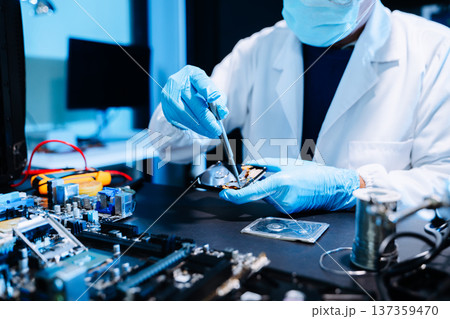 Professional technician repairing hard drive for data recovery in modern technology lab. Digital storage, cybersecurity, hardware repair and data protection concept. 137359470