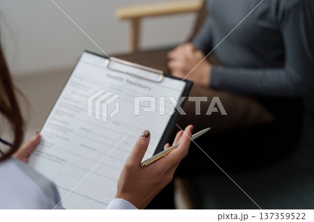 Health Consultation. A healthcare professional discussing a patient's health summary. Health Consultation. A healthcare professional discussing a patient's health summary. 137359522