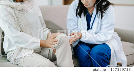 Doctor examining elderly woman with knee pain during home healthcare visit, highlighting arthritis treatment, senior support, medical consultation 137359738