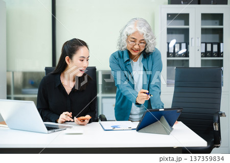 Kind leader executive manager share and discuss business solutions plan ideas on tablet with Asian female marketing manager in modern office. 137359834