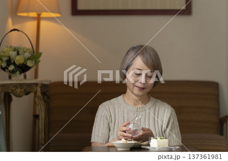 リビングで晩酌をするシニア女性 リビングで晩酌をするシニア女性 137361981