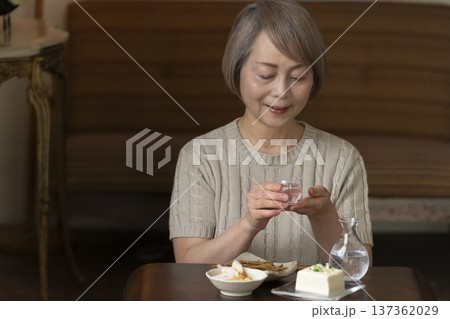リビングで晩酌をするシニア女性 137362029